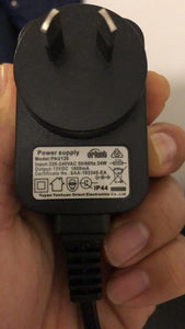 Hand holding a black replacement power adapter